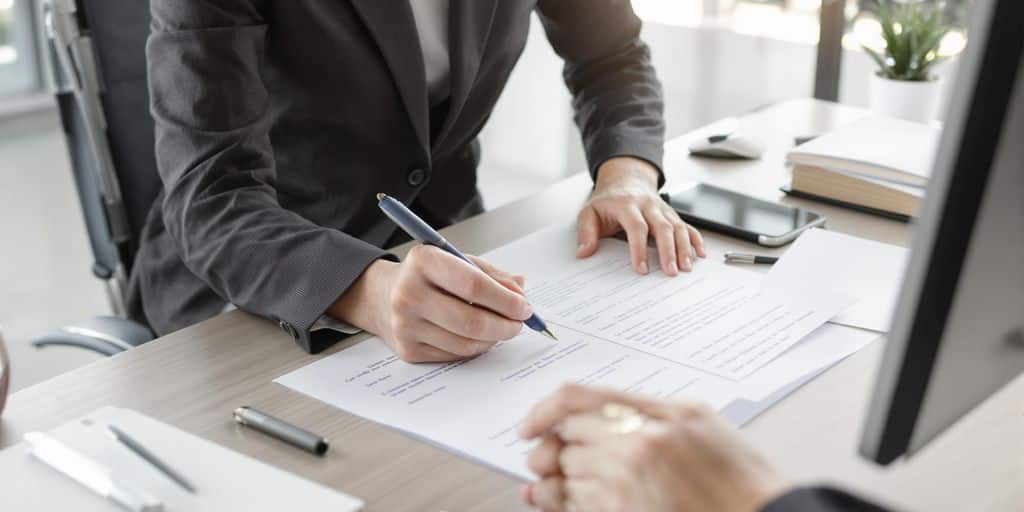 Person in business attire preparing documents at modern desk.