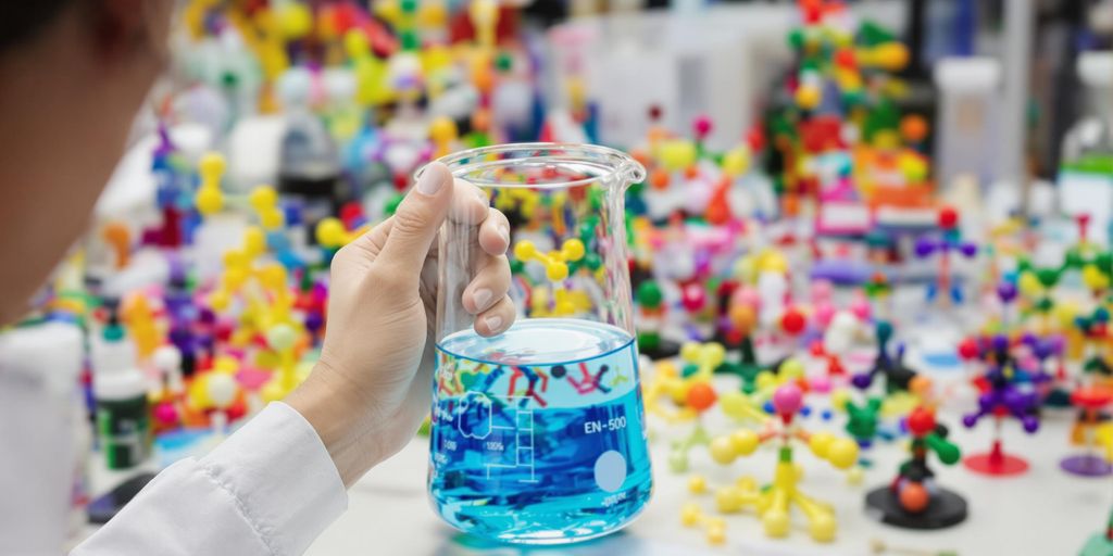 Chemist with beaker and molecular model.