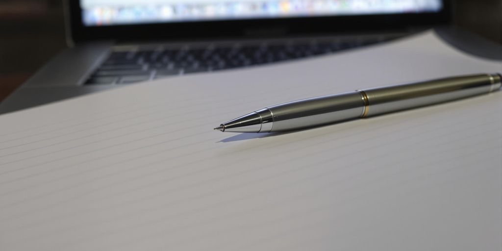 Clean, crisp resume document with a pen and laptop.