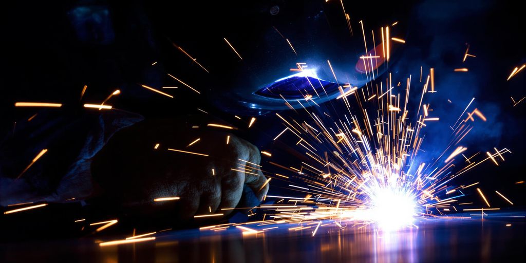 Welder in action, sparks flying, bright light