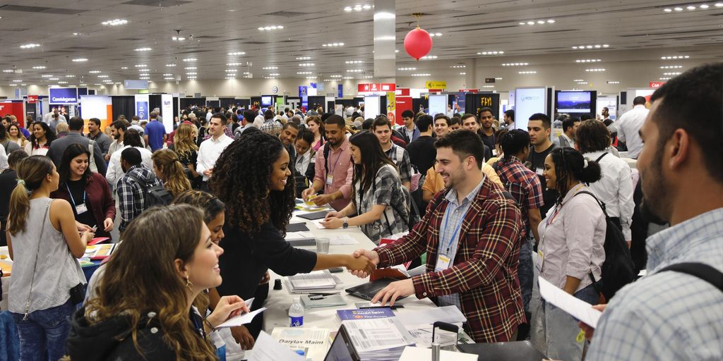 Diverse adults networking at a busy job fair.
