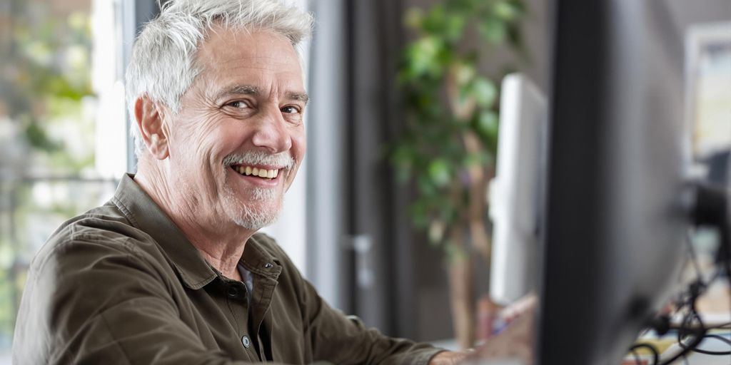 Smiling older person at computer.